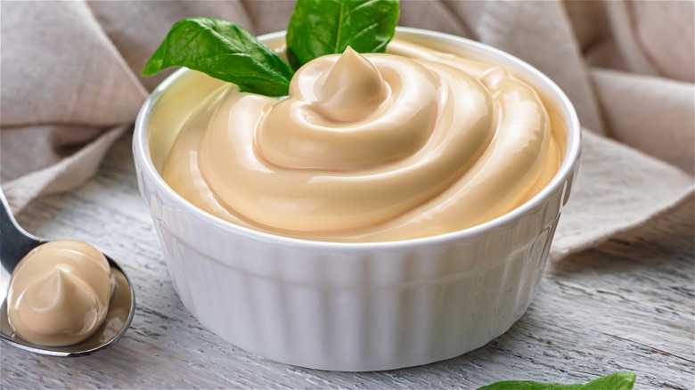 Mayo in white ramekin with fresh basil garnish