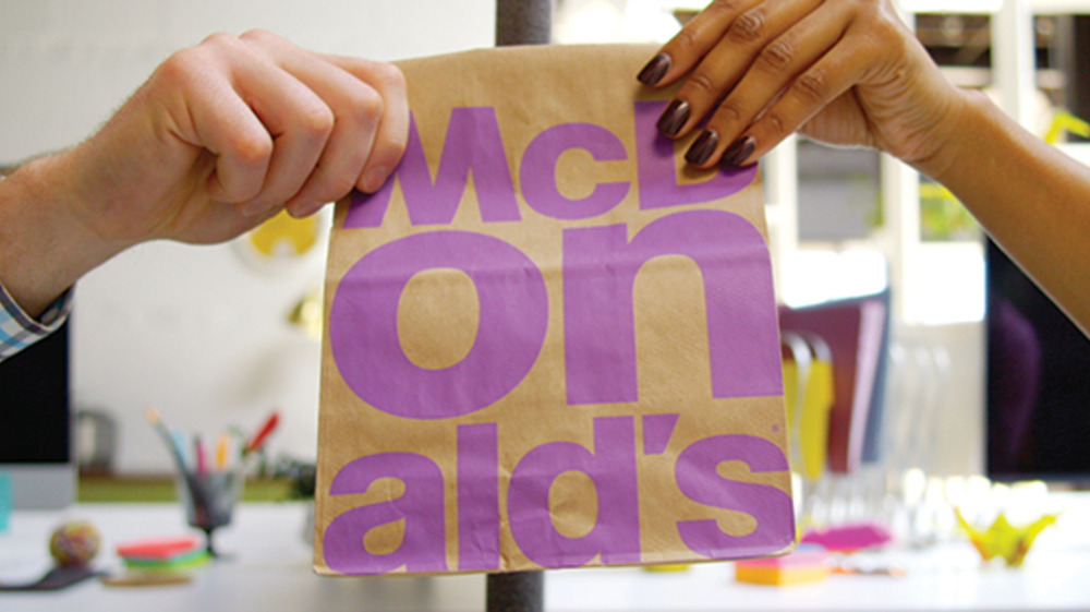 Two people hold McDonald's bag