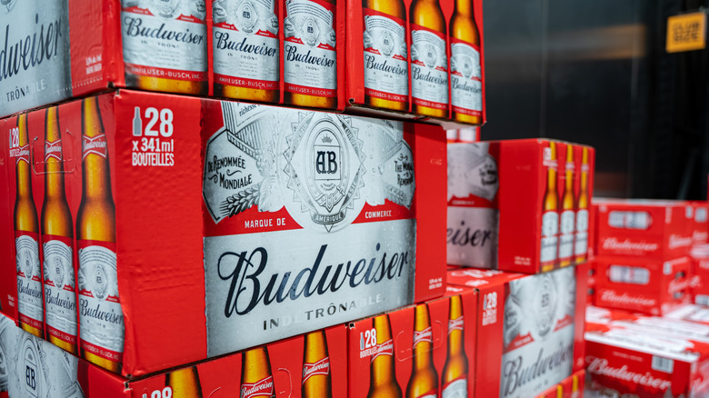 Red boxes of Budweiser beer stacked in warehouse.