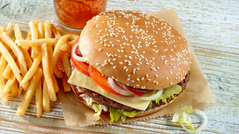 Fast food hamburger, french fries, and soda on table.