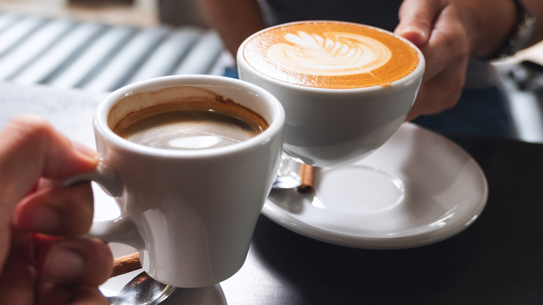 Hands holding two cups of coffee