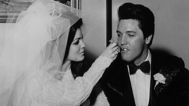 Elvis Presley and Priscilla Ann Beaulieu eating their wedding cake