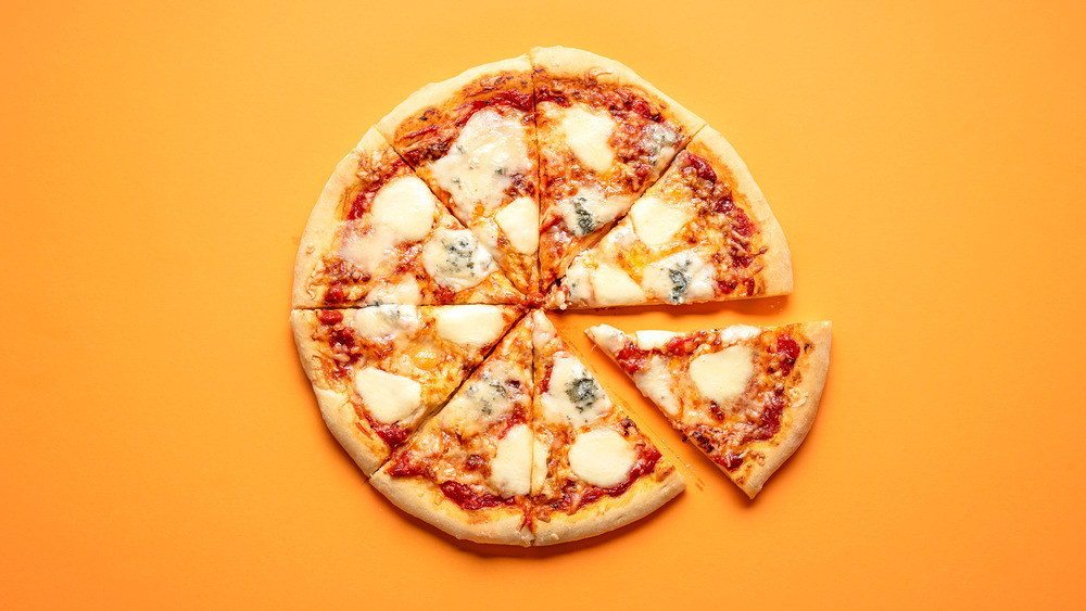 Pizza cut into slices on an orange background