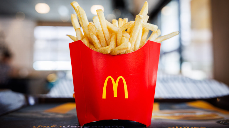 Container of fries on table inside a McDonald's