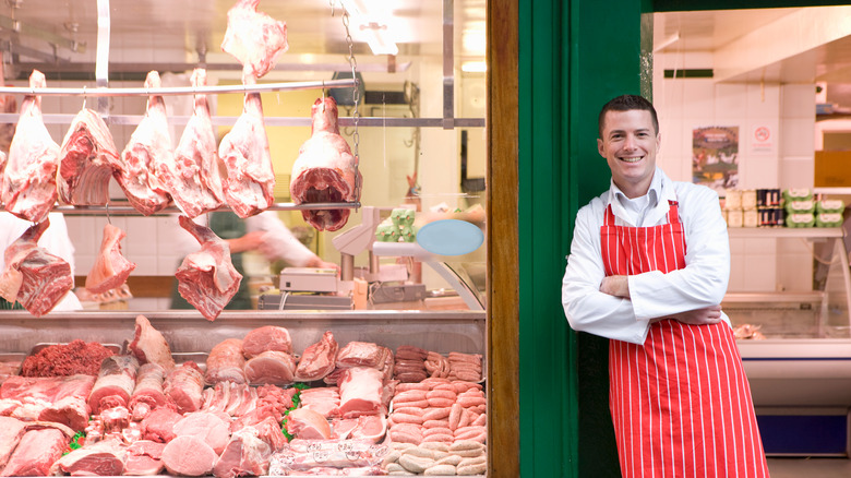 Butcher in front of butcher shop