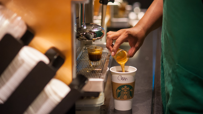 Closeup image of a Starbucks barista pouring a shot of espresso