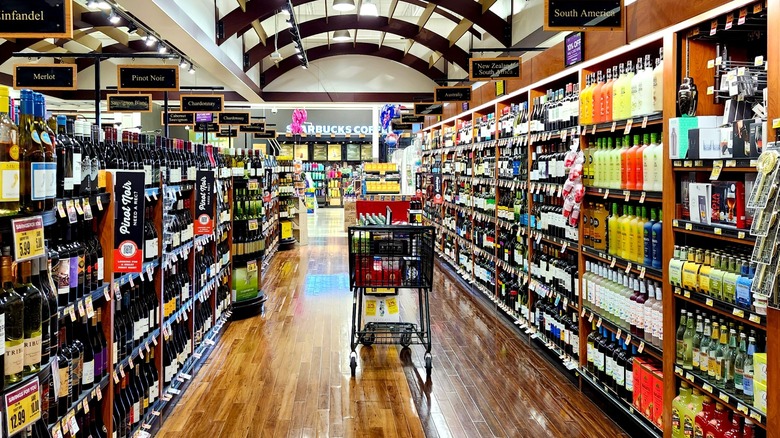 A shopping cart in the alcohol aisle of a grocery store