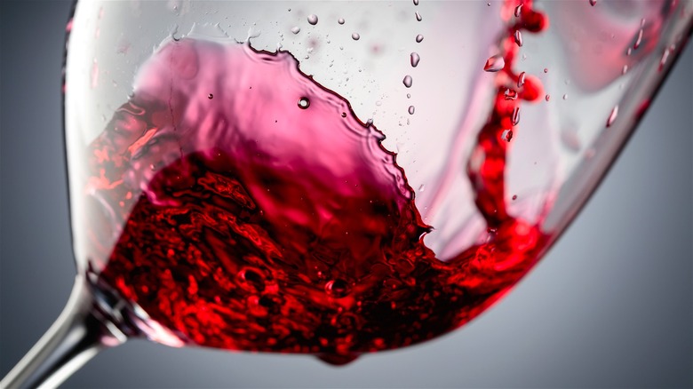 Red wine being swirled inside a glass.