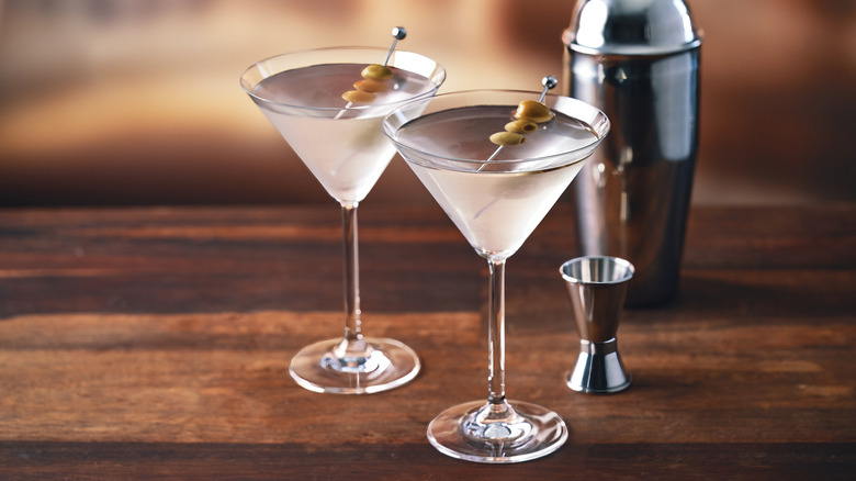Two vodka martinis garnished with olives.