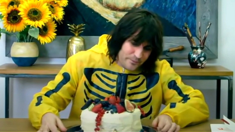 Noel Fielding inspecting a cake 