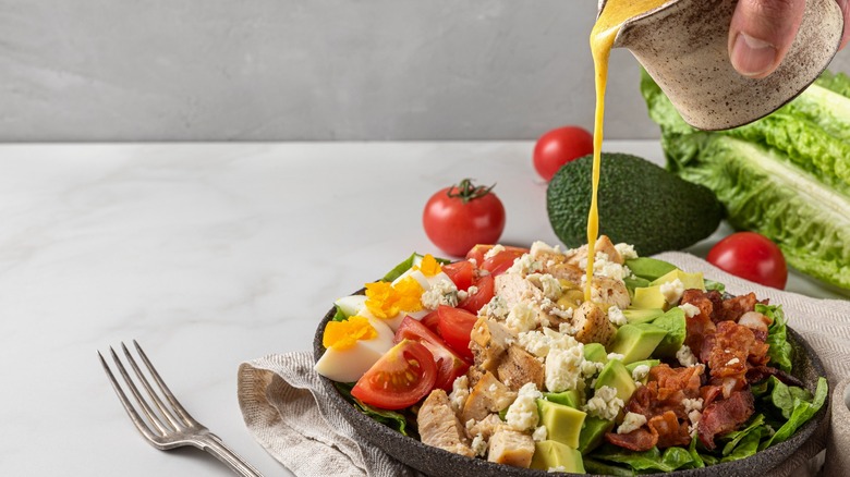 pouring dressing onto salad