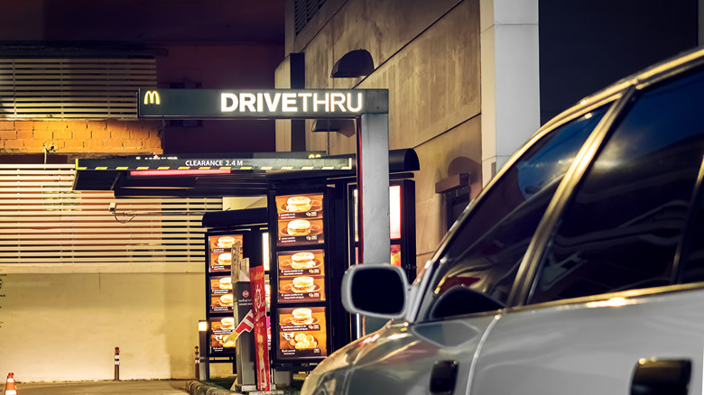 Car approaching McDonald's drive-thru at night