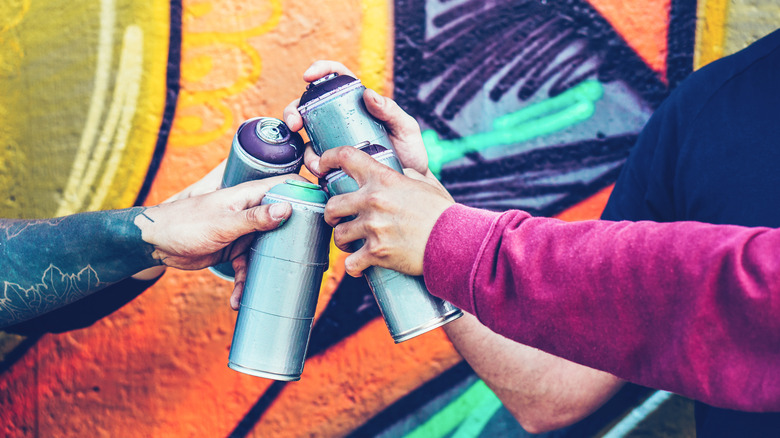 Hands with spray paint cans