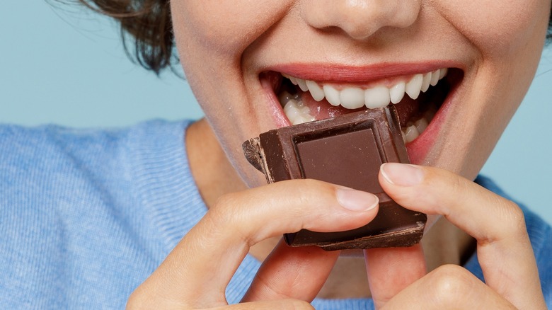 feminine face biting into chocolate