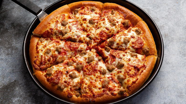 Sausage pizza in pan on gray background.