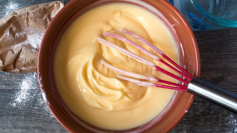 vanilla pudding in bowl with whisk