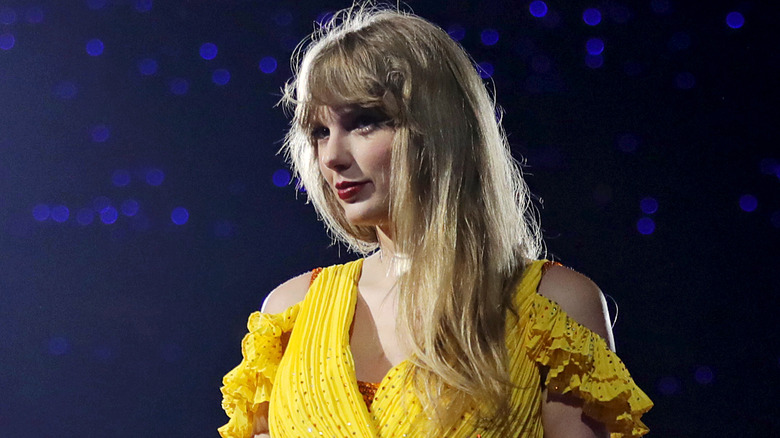 Taylor Swift on Eras tour in yellow dress