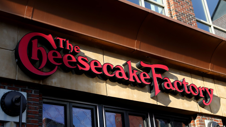 Red Cheesecake Factory logo on exterior of brown building