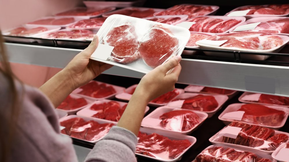 Woman buying meat at the grocery store