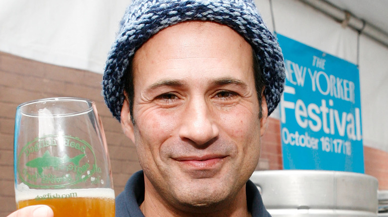 Sam Calagione holding up a beer