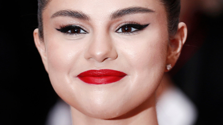 selena gomez smiing and wearing bold lipstick