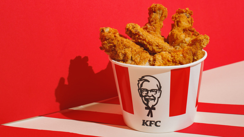 Bucket of Kentucky Fried Chicken against red wall