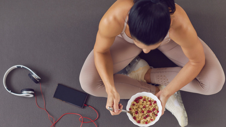 girl eating cereal on the floor with headphones