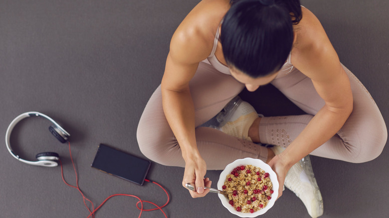 girl eating cereal on the floor with headphones