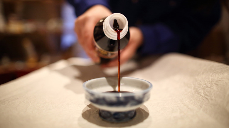 Pouring soy sauce into a dish