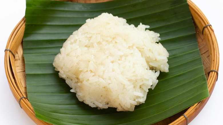 ball of sticky rice on a banana leaf sitting on a bamboo basket