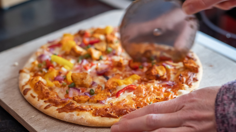 Cooked pizza being cut