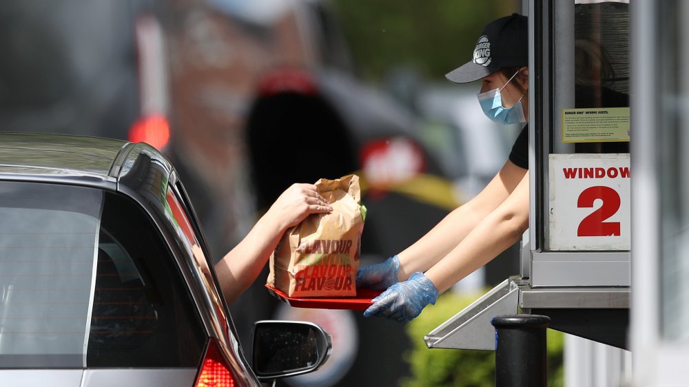 Burger King worker serving car through drive-thru