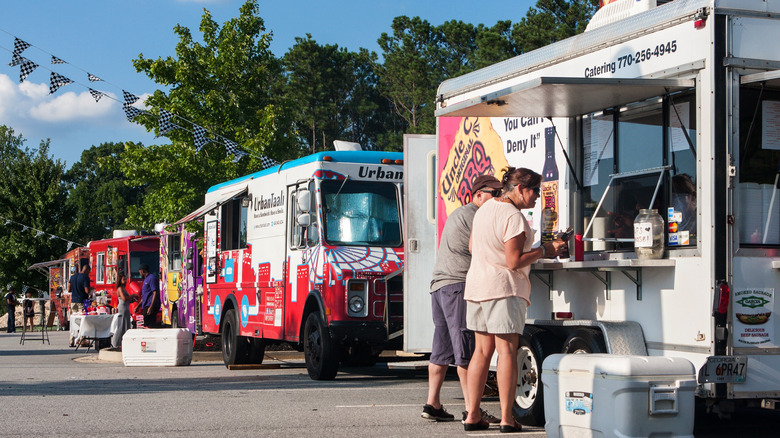 Food trucks in a row on grey pavement