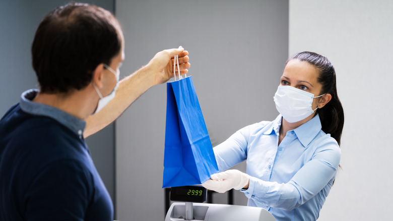 Cashier handing customer a bag