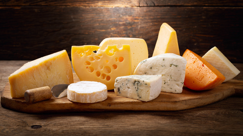 Assorted cheese on wooden cheeseboard