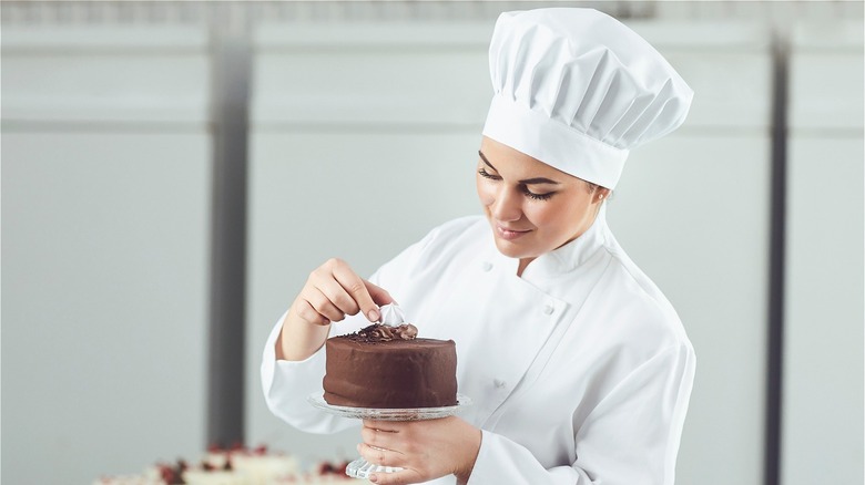 Chef in uniform handling cake