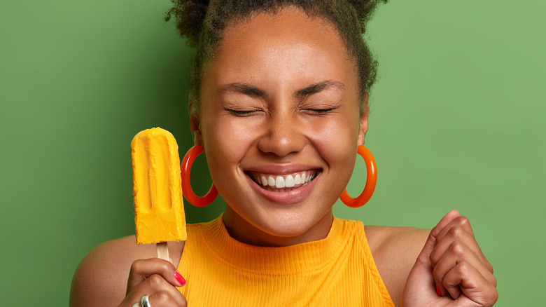 A woman holding a popsicle