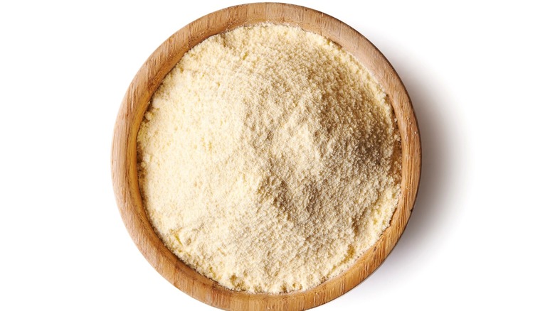 Dry white cornmeal in wooden bowl