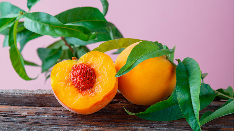 peaches cut open on wood board