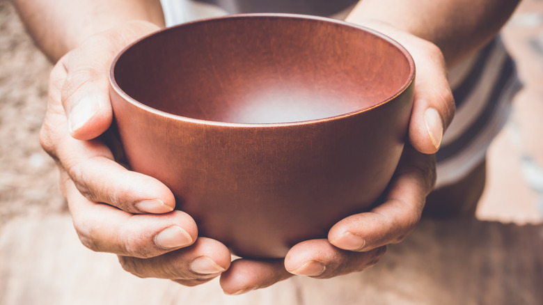 A person holding an empty bowl