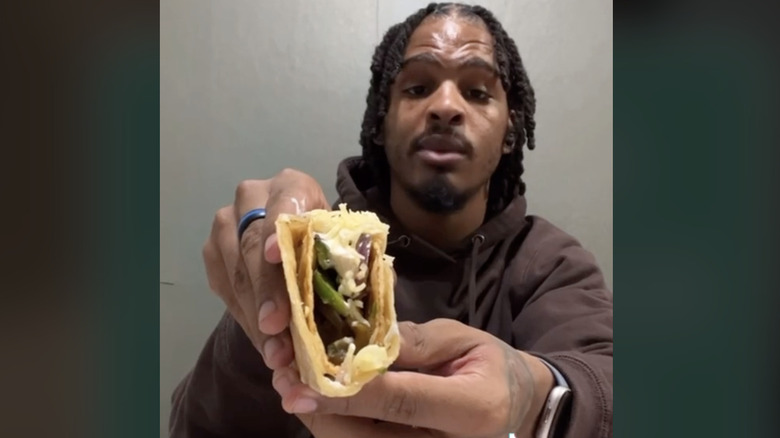Keith Lee holding a chipotle taco