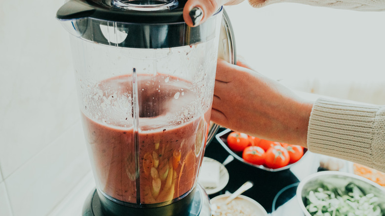 Person making smoothie in blender