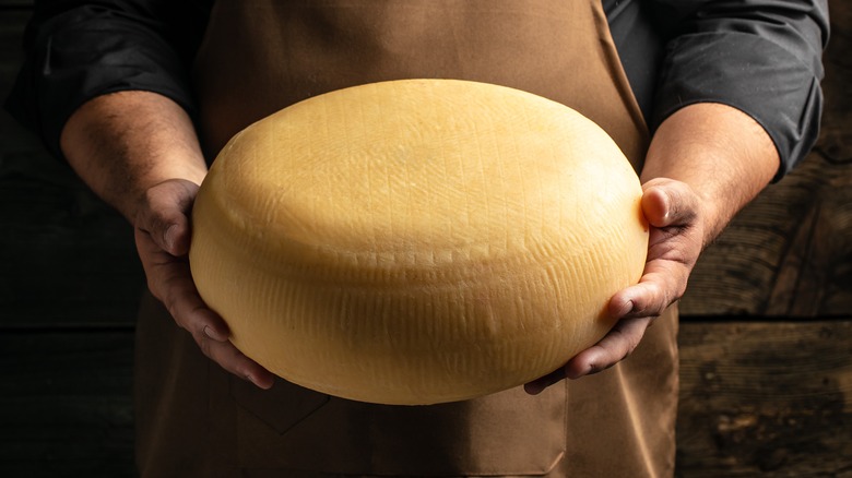 cheesemaker holding cheese