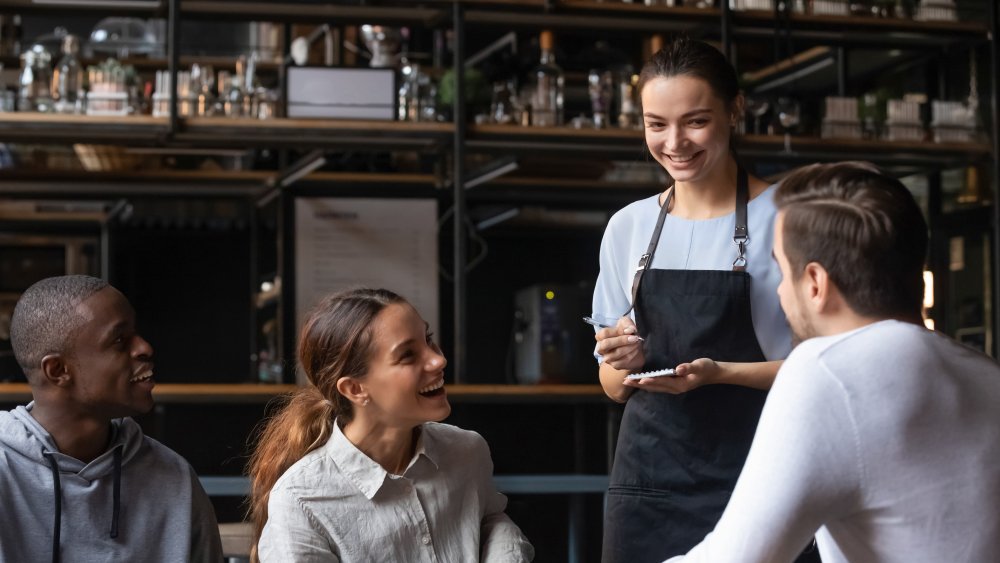 Server taking order from table full of diners