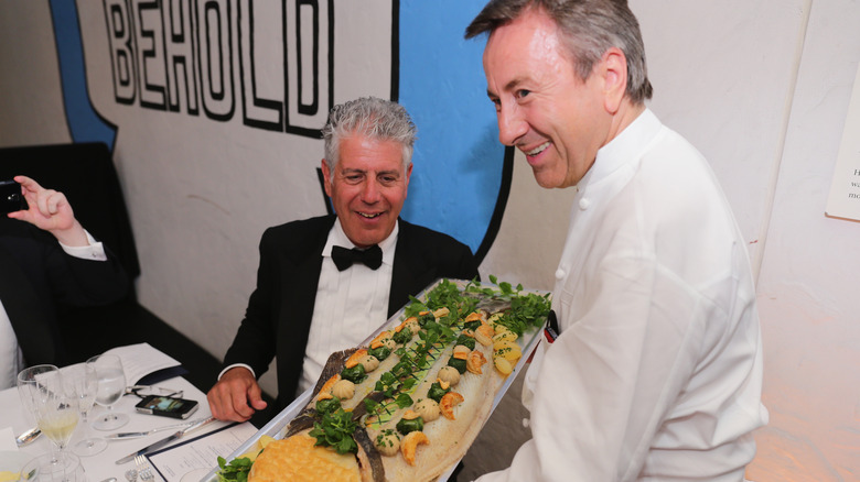 Anthony Bourdain being presented a dish