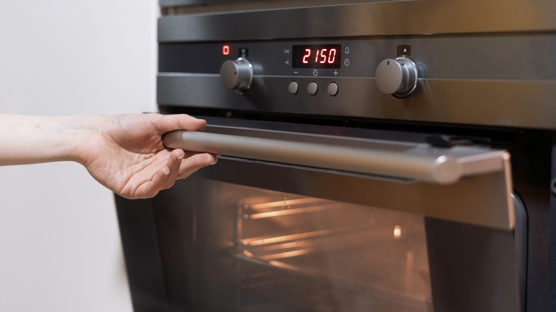 Person opening dirty oven door