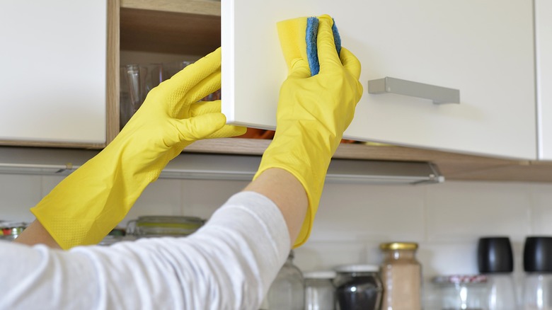 Person wipes down cabinets