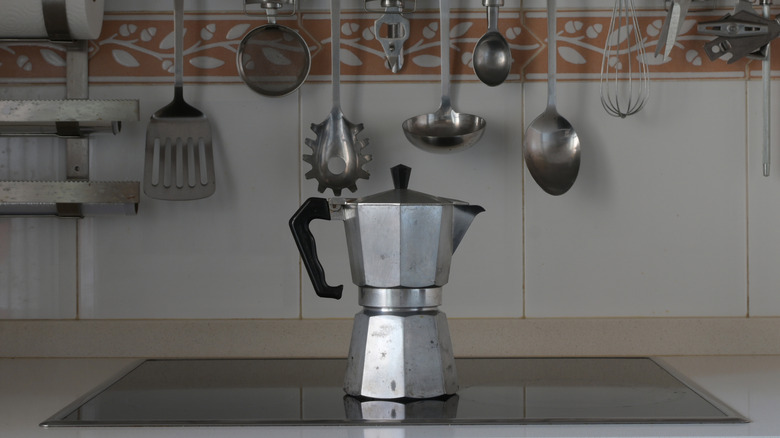 A moka pot on a stove top.