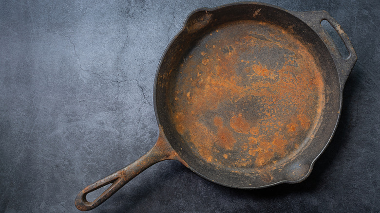 Rusty cast iron skillet on slate table top