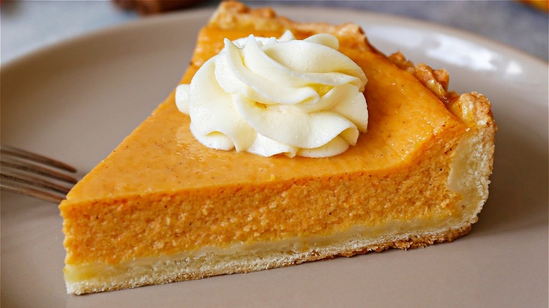 slice of pumpkin pie topped with whipped cream